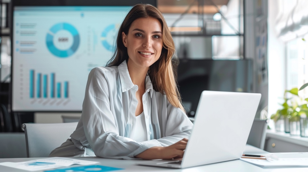 woman-sits-desk-with-laptop-blue-chart-that-says-business